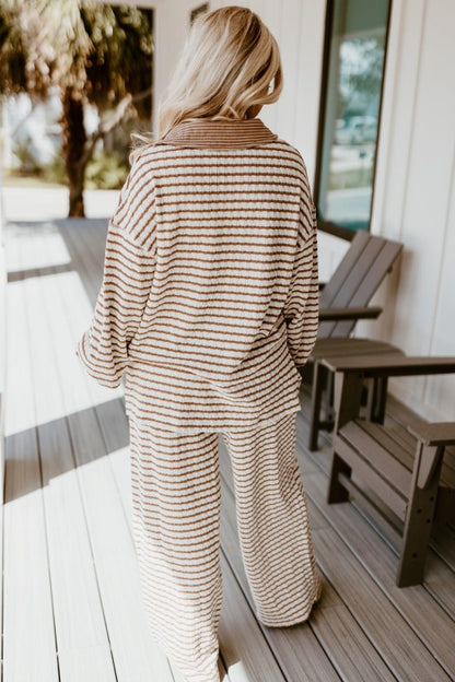 Person wearing a striped outfit on a wooden deck