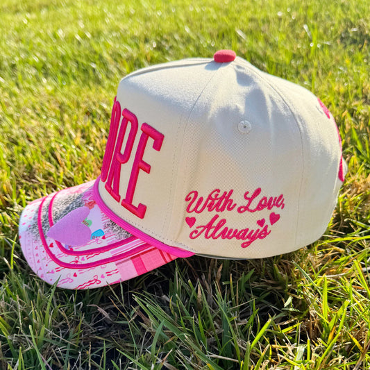 Cap with pink text on grass
