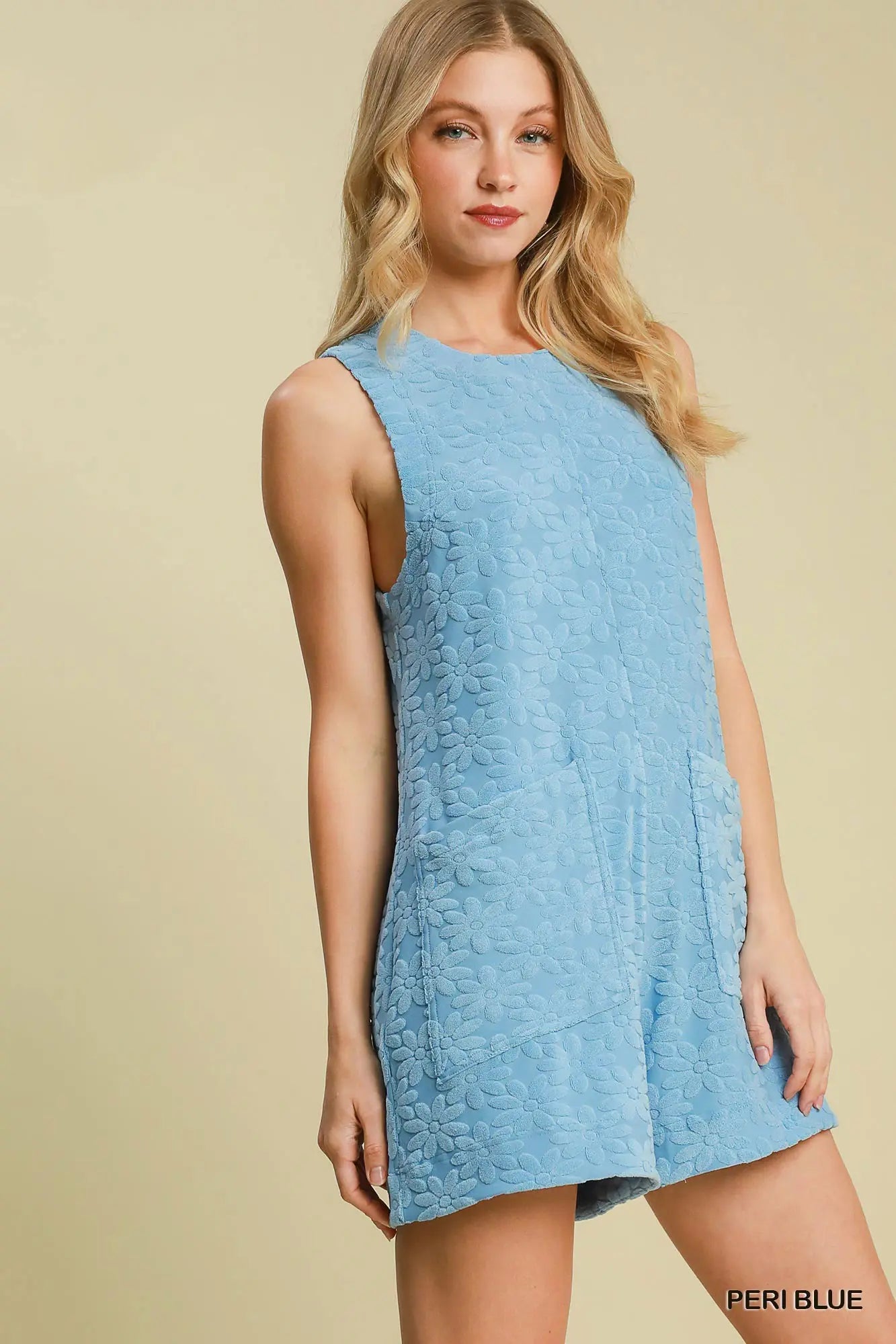 Woman wearing a light blue sleeveless dress on a beige background
