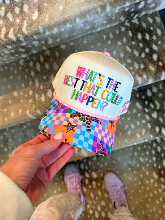 Colorful cap with text held by a hand on a patterned floor