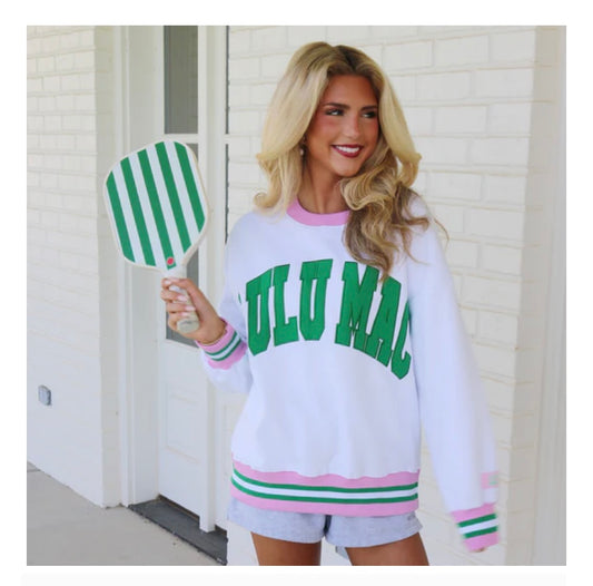 Woman wearing a white sweatshirt with 'FULMAD' and shorts, holding a green and white striped paddle.