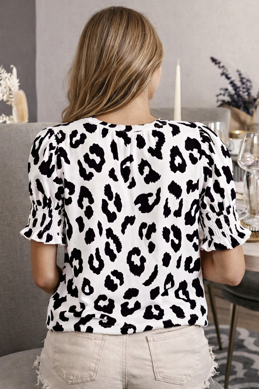 Person wearing a leopard print top in a casual setting