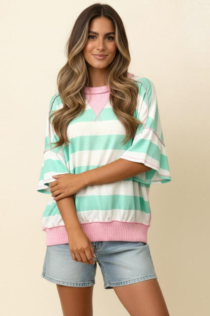 Woman wearing a striped shirt with pink and green colors on a beige background