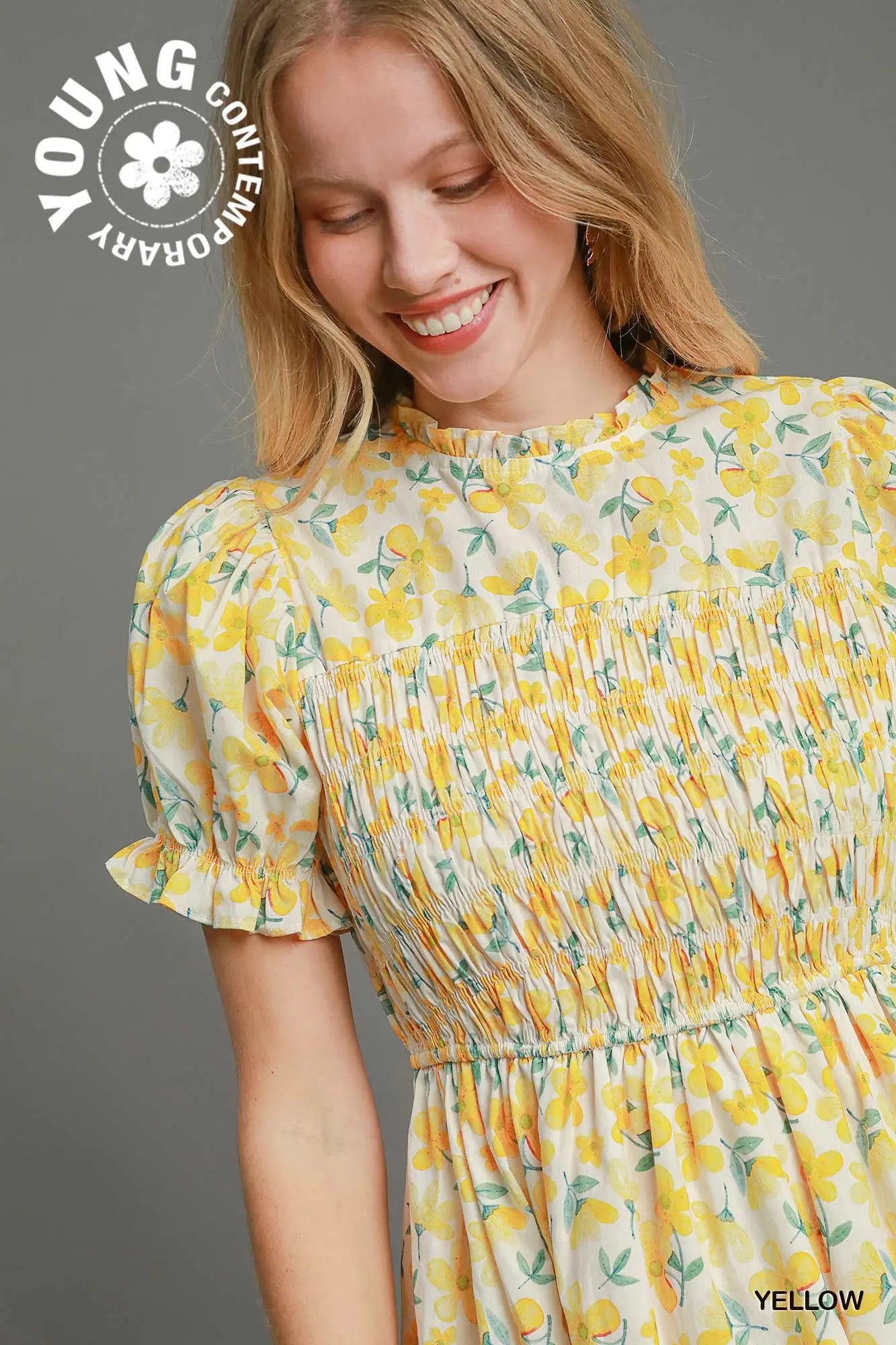 Woman wearing a yellow floral dress with 'Young Contemporary' branding.