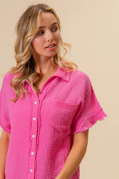Woman wearing a pink short-sleeve shirt against a beige background