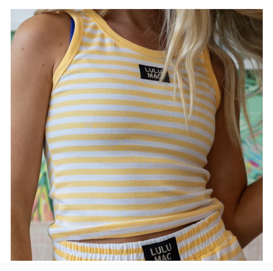 Yellow and white striped tank top with 'Lulu Mac' branding on a person.
